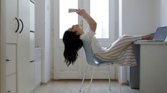 A woman sitting on a chair and reading.